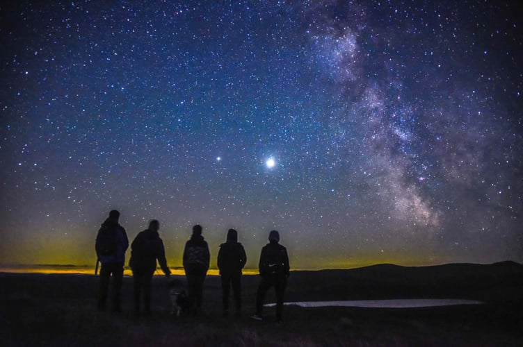 Walkers on a trail at night as part of Visit Wales dark skies trail blazers campaign