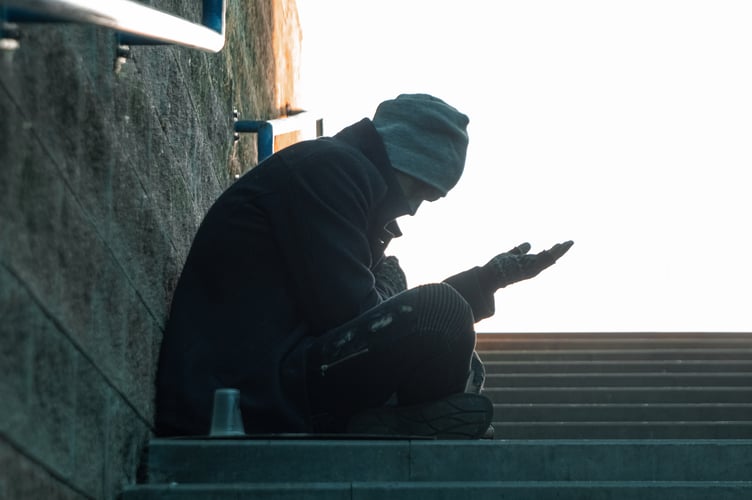 A man, homeless, a person asks for alms on the street with a Help sign. concept of homelessness, social problem, drug addict, poverty, despair