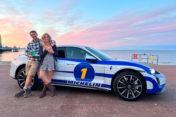 Vanessa Ruck and husband posing next to a racing car