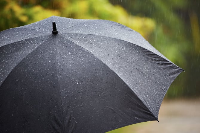 Black umbrella in heavy rain - selective focus