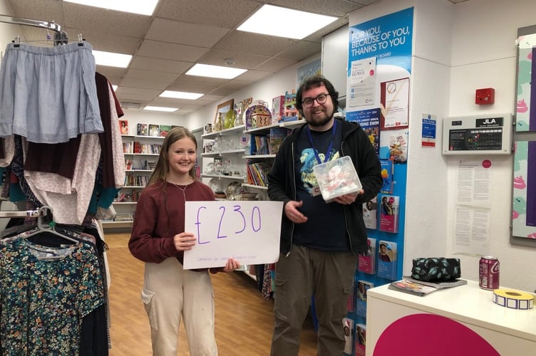 John Kyrle High School pupil giving the funds raised to Cancer Research UK