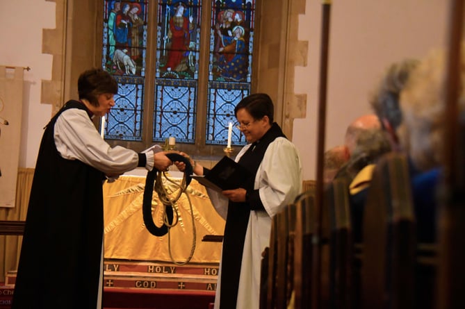 Bishop Rachel presents a symbolic bell rope to Rev Lara Bloom
